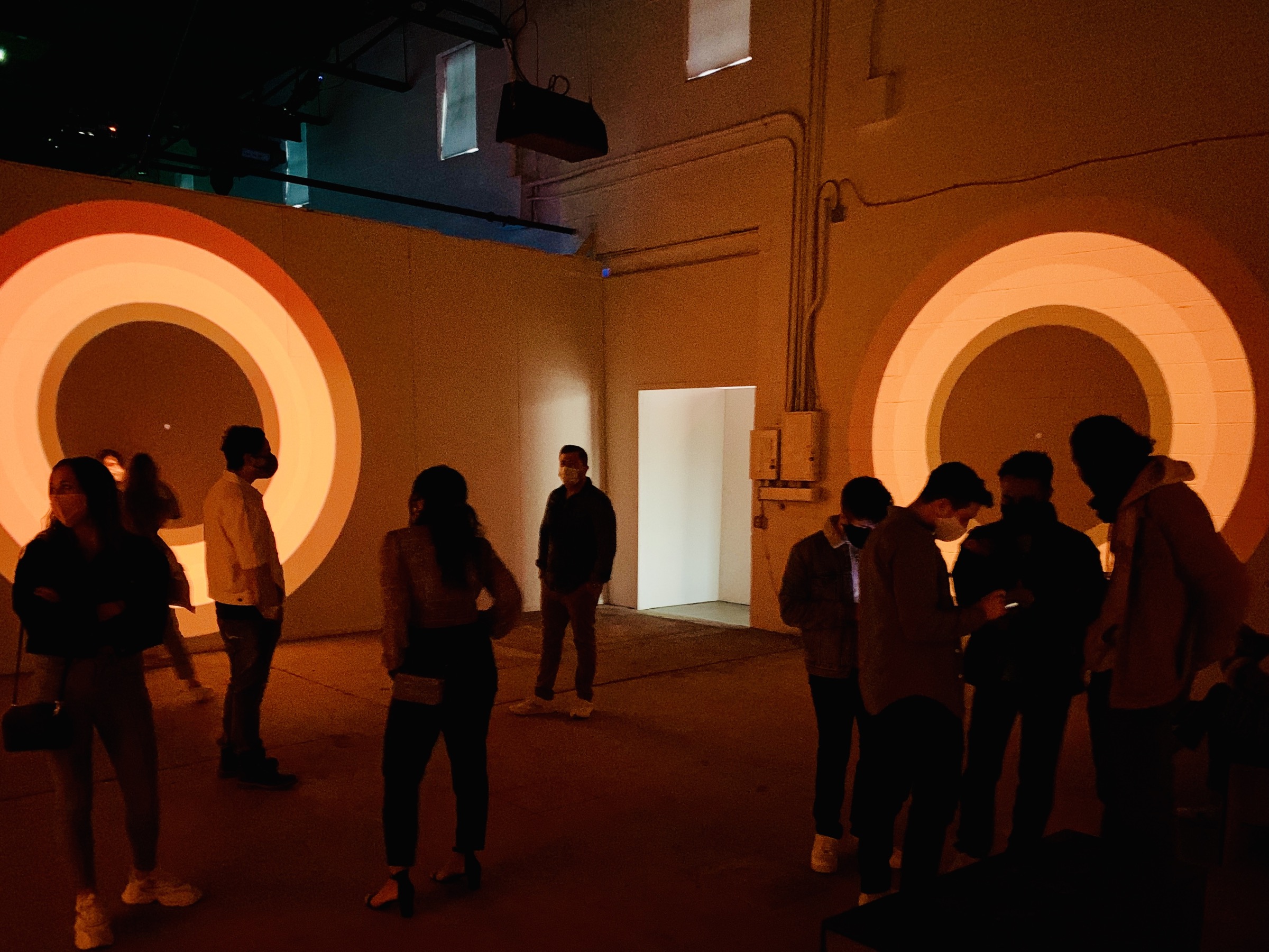 Visitors gathered between circular orange projections inside Spacecraft
